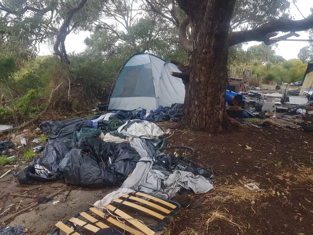 A photo of Kwinana's Squatter Camp where you can see a tent and huge bags of rubbish.